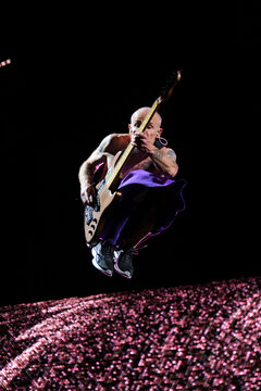 Red Hot Chili Peppers’ bassist Flea leaps in the air as the band performs. Spending the entire show shirtless, Flea jumped and moved around the stage.