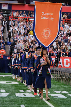 The Valedictorians, University Scholars and Class Marshals lead the Class of 2023 down the field. Simone Bellot, on the marshals, carried the university’s banners.  