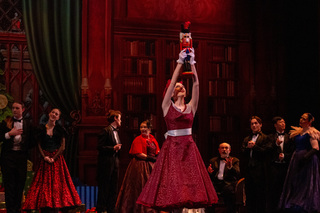 Clara, performed by Penelope Lane, holds up her nutcracker, which she receives from Godfather Drosselmeyer. The nutcracker was the main prop Clara danced with throughout Act I. 