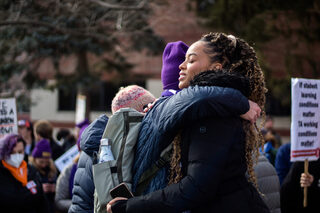 Riansimone Harris, a Black Graduate Student Association representative, and an SGEU representative embrace each other in a hug after the march comes to an end. SGEU members and supporters stayed to celebrate the conclusion of a successful turnout.