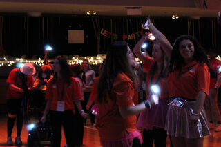 Participants turn on their phone flashlights and dance about in the dimmed lights as the night starts to come to a close. The slower music gave dancers a chance to relax a little bit without fully taking a break from the 12 hour dance marathon.