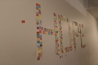 Paint swatches with notes from dancers written on them spell out “hope” on the wall in Goldstein Auditorium. Participants were invited to write what encouraged them to participate in OttoTHON on the swatches and hang them up. 
