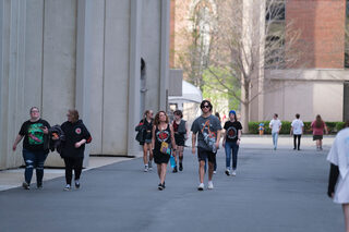 Concert-goers walk to the JMA Wireless Dome wearing merchandise from one of three performing artists. Fans came from Syracuse and beyond in order to attend the Red Hot Chili Peppers’ fifth tour location.