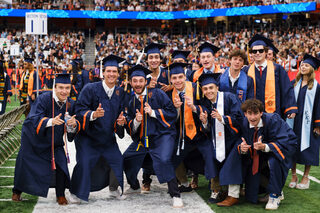 Graduates from SU’s School of Visual and Performing Arts pose for a photo before taking their seats for the commencement ceremony. Their caps and gowns gleamed from the Dome’s lights and the flashes from their families' phone cameras. 