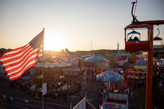 The sun sets over the New York State Fair and puts a cap on the summer as students head back to school and the weather starts to turn cooler. From the Broadway Skyliner fairgoers can oversee the crowds gathered at games, getting food and waiting in line to ride rides in the Midway.