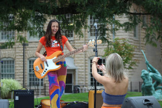 Goldie Singer, bassist for Bella Fiske, laughs as an audience member captures the moment with a digital camera. The singer expressed the sentiment that she holds for her instrument, calling it her “precious bass.”
