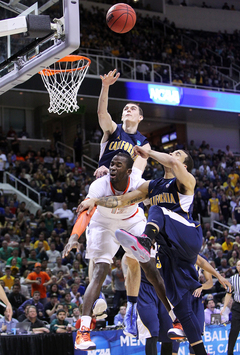 Baye Moussa-Keita #12 loses possession of the ball as he drives to the basket against California's Justin Cobbs #1 and David Kravish #45.