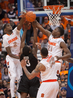 From left to right: Syracuse's B.J. Johnson, Coleman and Tyler Roberson block Reed in the paint. 