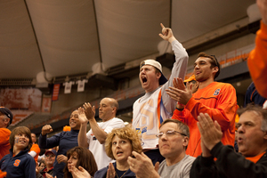 (From left to right) Andrew Schonholtz and Rayhaan Nagrath, recently graudated seniors from Syracuse University, cheer as Syracuse defeats Bryant in first round of the 2013 NCAA tournament.