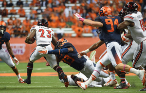 SU linebacker Marqez Hodge tries to bring down Louisville running back Brandon Radcliff during UofL's 28-6 victory.