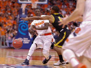 Syracuse freshman point guard Kaleb Joseph, closely guarded up top, looks to pass to his right.