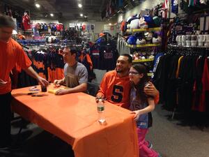 Former Syracuse point guard Tyler Ennis poses for a photo with a fan while he signs autographs at My Favorite Sports Store in Destiny USA on Saturday afternoon.