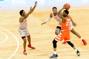 Frank Howard holds the ball above his head at the top of the key.