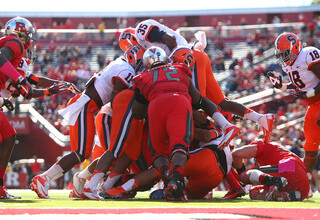 Syracuse linebackers Dyshawn Davis (35) and Marquis Spruill (11) are among a group of defenders trying to stuff the Rutgers offense.