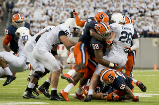 A host of SU defenders, including linebacker Cameron Lynch, swarm PSU running back Zach Zwinak.