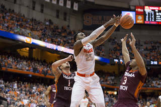 Christmas tries to corral the ball with Hokies guards Malik Muller (1) and Adam Smith (3) on either side of him.