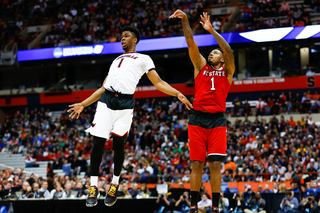 Lacey follows through on a shot while the Cardinals' Anton Gill spins in the air in an attempt to defend.