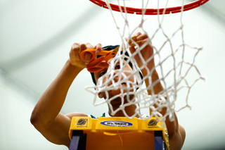 Forbes cuts a piece of the net following the team's win.