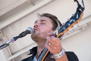 LOLO's band member soaks up the sun at Skytop field as he sings along with her.