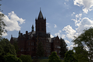 Scaffolding was erected along the front of Crouse College as crews restore the building's clock tower masonry. Photo taken July 5, 2017