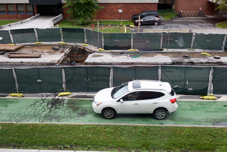 A vehicle drives along a narrow path beside the sewer line replacement project on Waverly Avenue. Photo taken July 25, 2017