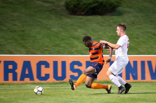 Miller slides into a ball near the corner of the field, looking to beat a Cornell player. 