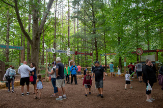 Games are set up in the wooded area of Beaver Lake Nature Center for families to play with nature themed spins on classic fair games such as ring toss.