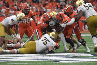 Syracuse defense closes in on the Notre Dame ball carrier as he tries to make his way down the field. The Orange tried to keep their opponents from getting a first down and advancing toward the end zone. 