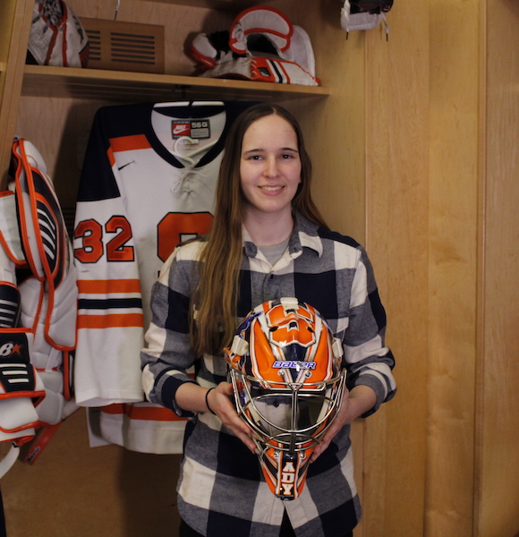 Ady Cohen holding her mask in front of her locker